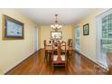Bright and spacious dining room featuring hardwood floors, a chandelier, and large windows at 14027 Springwater Dr, Matthews, NC 28105