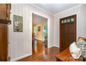 Inviting hallway featuring hardwood floors, neutral wallpaper, and an open doorway to the dining area at 14027 Springwater Dr, Matthews, NC 28105