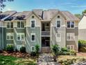 Exterior view of a two-story condominium building with light green siding, white trim and dormer windows at 19901 Henderson Rd # M, Cornelius, NC 28031