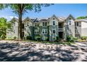 Exterior view of a two-story condominium building with light green siding, white trim and dormer windows at 19901 Henderson Rd # M, Cornelius, NC 28031