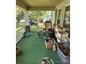 Untidy covered front porch cluttered with various household items and supplies at 208 E Main St, Cleveland, NC 27013