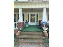 Covered front porch with brick supports and steps leading up to the entrance at 208 E Main St, Cleveland, NC 27013