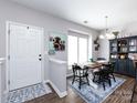 Bright entryway with a dining area featuring rustic table, cabinet and stairs with safety gate at 2147 Lake Breeze Ln, Denver, NC 28037