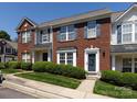Attractive townhome featuring brick facade, blue shutters, landscaping, and covered entry to create a curb appeal at 2147 Lake Breeze Ln, Denver, NC 28037