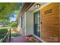 Inviting front entrance featuring a stained wood accent wall, stylish door, and welcoming mat at 232 Scottridge Dr, Charlotte, NC 28217