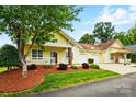 Inviting yellow home with manicured landscaping and an attached two car garage at 2323 Granville Pl # A, Monroe, NC 28110
