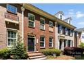 Charming brick townhome featuring a black front door, well-maintained landscaping, and large windows for natural light at 2485 Shanklin Ln, Denver, NC 28037