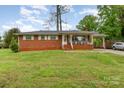 Charming red brick home featuring a cozy front porch and a convenient carport with a well-maintained lawn at 2885 Wright Ave, Salisbury, NC 28147
