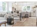 Cozy, open-concept living space and kitchen featuring modern light fixtures and light hardwood floors at 318 Sixth St, Belmont, NC 28012