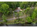 A high angle view of a home featuring lush landscaping, a detached garage, and serene pond views at 5100 Crestland Ave, Charlotte, NC 28269