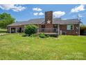A sprawling green lawn with a brick home featuring a backyard deck and ample space at 5873 Alexis Ln, Vale, NC 28168