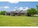 Beautiful brick home showcasing lush landscaping and a well-maintained lawn at 5873 Alexis Ln, Vale, NC 28168