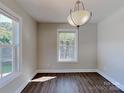 Bright dining room with ample sunlight, modern chandelier, and wood-style flooring at 668 Smith St, Kannapolis, NC 28083