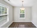 Inviting dining room featuring wood-look flooring, a modern chandelier, and natural light from large windows at 668 Smith St, Kannapolis, NC 28083