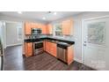 Efficient kitchen featuring stainless steel appliances, granite countertops, and wood cabinets with an exterior door to the backyard at 668 Smith St, Kannapolis, NC 28083