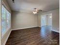 Spacious living room with wood-style flooring, large windows, and contemporary ceiling fan at 668 Smith St, Kannapolis, NC 28083