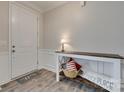 Warm foyer with wood floors, white wainscoting and a decorative table at 7049 Irongate Dr, Indian Land, SC 29707