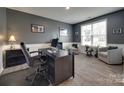 Home office features wood floors, neutral paint, a large window and ample seating at 7049 Irongate Dr, Indian Land, SC 29707