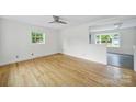 Bright, airy living room featuring hardwood floors, neutral paint, and a contemporary ceiling fan at 7412 Woodstream Dr, Charlotte, NC 28210