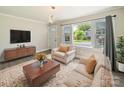 Cozy living room with a modern chandelier, a neutral-toned sofa set, and a view of the outdoors at 83 Woodsdale Se Pl, Concord, NC 28025