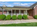 Inviting front porch with white railings and classic brick facade at 8520 Wright Rd, Kannapolis, NC 28081