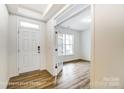 Bright foyer with hardwood floors, white trim and paint, and a view into the home's interior at 8619 Frank Grier Rd # 3, Charlotte, NC 28215