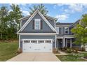Charming two-story home with a two car garage, stone accents, and neatly manicured landscaping at 980 Prince Garrett Way, Denver, NC 28037