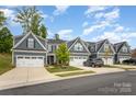 A row of charming two-story homes featuring garages, stone accents, and well-maintained lawns at 980 Prince Garrett Way, Denver, NC 28037