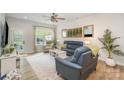 Bright living room with stylish furniture, hardwood floors, and a large window overlooking the backyard at 980 Prince Garrett Way, Denver, NC 28037