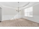 Spacious dining room with a chandelier, wainscoting, and natural light at 10008 King George Ln, Waxhaw, NC 28173