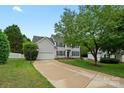Well-maintained two-story home with attached garage, lush lawn, and mature trees in a pleasant neighborhood at 10434 Blackstock Rd, Huntersville, NC 28078