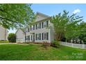 Charming two-story home featuring manicured landscaping, black shuttered windows, and attached garage at 10434 Blackstock Rd, Huntersville, NC 28078