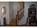 Foyer features hardwood floors, staircase with wood railing, and decorative shelving at 10434 Blackstock Rd, Huntersville, NC 28078
