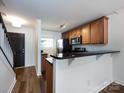 Functional kitchen area featuring wood cabinets, stainless steel appliances, and a convenient breakfast bar at 1348 Green Oaks Ln # L, Charlotte, NC 28205