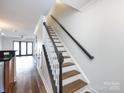 Elegant staircase showcasing wood steps, white risers, and dark trim, leading to the upper level at 1348 Green Oaks Ln # L, Charlotte, NC 28205