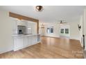 Open-concept living room with hardwood floors, modern lighting and open access to kitchen at 15333 Catawba S Cir, Matthews, NC 28104