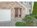 Inviting front entrance with stone archway, classic wood door, and landscaped greenery at 2441 Chatham Dr, Fort Mill, SC 29707