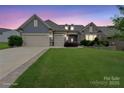Inviting two-story home with a well-manicured lawn and a three car garage at dusk at 3537 Plum St, Fort Mill, SC 29715