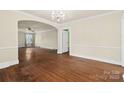 Bright and open living room with archway, hardwood floors, and chandelier at 4608 Beatties Ford Rd, Charlotte, NC 28216