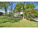 Green lawn and mature trees surround this charming two-story home's exterior at 4738 Truscott Rd, Charlotte, NC 28226