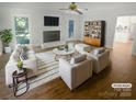 Bright living room features a brick fireplace, stylish furniture and decor, and wood floors at 5013 Prestwick Ln, Charlotte, NC 28212
