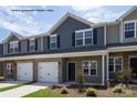 Newly constructed townhomes with gray facade, garages and manicured lawns at 5153 Tommy Ln # 1104, Stanley, NC 28164