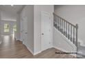 Hallway and stairway showcasing new construction home interior with light walls and wooden floors at 5153 Tommy Ln # 1104, Stanley, NC 28164