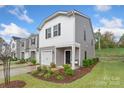 Well-maintained townhome showcasing landscaping, a single car garage and cozy front porch at 518 Tayberry Ln, Fort Mill, SC 29715