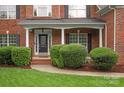 Elegant brick home entrance with white columns and detailed front door with manicured shrubbery at 601 Carver Pond Ln, Waxhaw, NC 28173