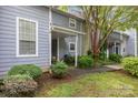 Inviting covered porch area surrounded by lush, green landscaping at 6011 Treetop Ct, Charlotte, NC 28212