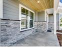 Inviting front porch with stone accents, siding and wood ceiling at 6027 Veld Ct # 82, Charlotte, NC 28215