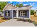 Charming blue home featuring a well-manicured lawn and dark shutters at 630 W Bell St, Statesville, NC 28677