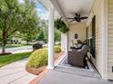 Cozy front porch featuring comfortable seating, neutral accents, and a ceiling fan for relaxed outdoor living at 7627 Woodcrest Dr, Stanley, NC 28164