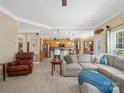 Inviting living room featuring an open layout with a view of the modern kitchen and a comfortable sectional sofa at 7627 Woodcrest Dr, Stanley, NC 28164